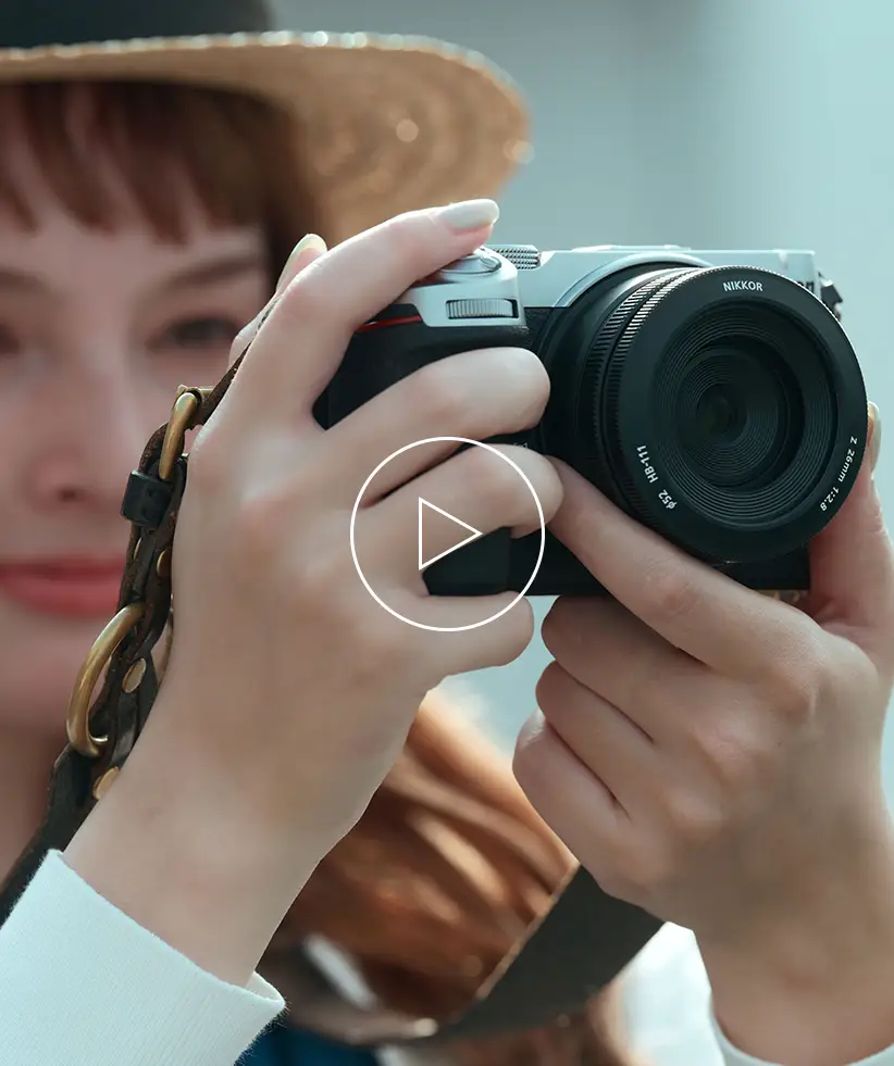 Girl in a sun hat holding a Nikon Z5IIC camera
